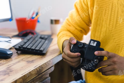 Preview: Closeup of a person using a modern digital camera under the lights