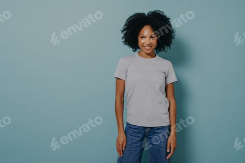 Preview: Delighted young african female posing isolated over blue background with pleasant smile