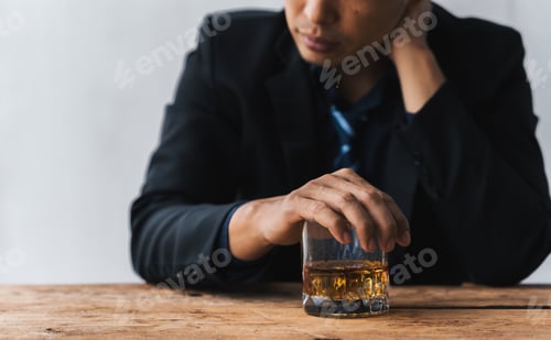 Preview: drunk asian man hold whisky glass addicted alcohol need therapy.