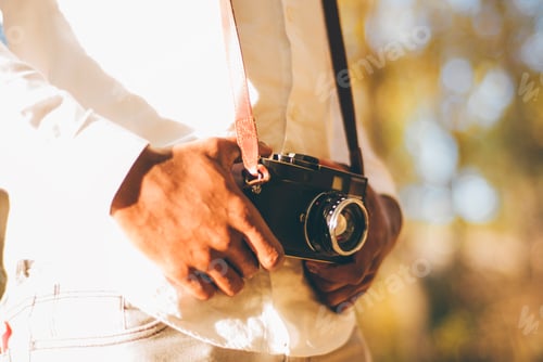 Preview: Man hands with vintage photo camera.