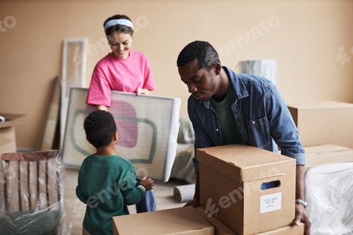 Preview: Young African American man putting cardboard box on top of another one