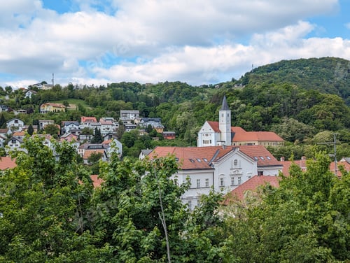 Preview: Beautiful cityscape scenery of buildings and architecture in old town surrounded by forest and hills