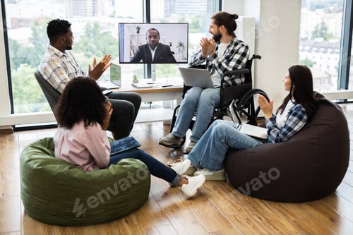 Preview: Team members applaud during virtual meeting with male colleague on screen