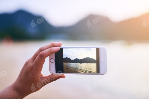 Preview: Somethings demand a photograph. Cropped shot of a young woman taking photographs at the beach.