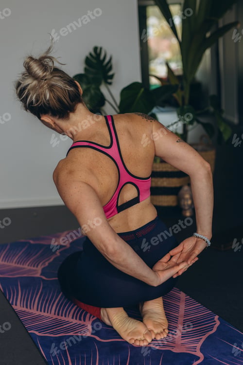 Preview: Attractive young woman practing yoga stretching yoga at home.