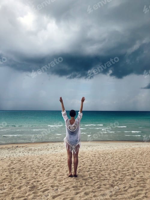 Preview: Woman standing on a beach in stormy weather