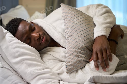 Preview: African American guy in terry robe sleeps sweetly on large bed