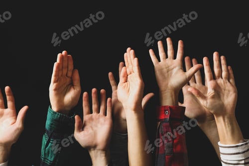 Preview: Hands of different people raised up on black background