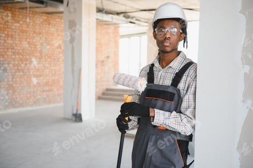 Preview: Construction worker holding paint roller on site
