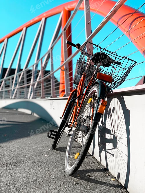 Preview: Bicycle Standing on City Bridge With Orange Geometric Pattern in Light and Shadows