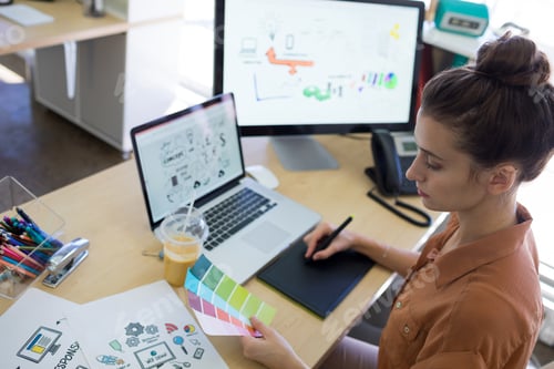 Preview: Female executive working over graphic tablet at her desk
