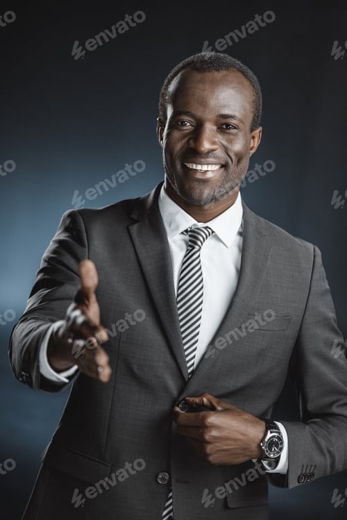 Preview: portrait of smiling african american businessman with outstretched hand looking at camera isolated