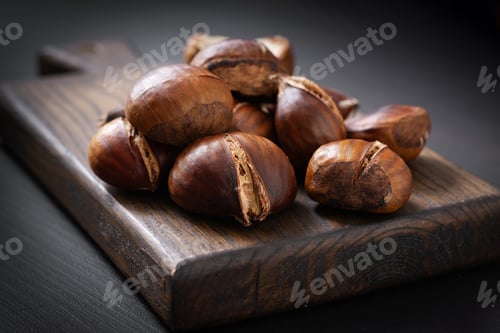 Preview: Roasted chestnuts on dark wooden background