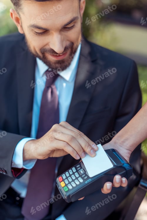 Preview: Close-up view man using contactless credit card on pos terminal