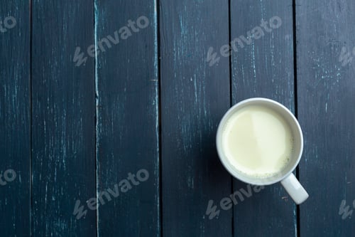 Preview: Glass of milk on table on blurred natural background