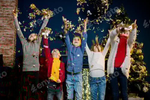 Visualização: Feliz cinco crianças caucasianas jogando confete e comemorando o Natal.