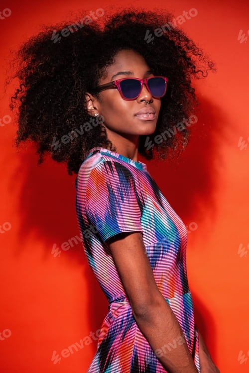 Preview: Black woman in vivid dress in studio