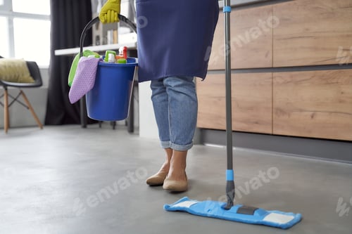 Preview: Cropped shot of a woman holding mop and plastic bucket or basket with rags