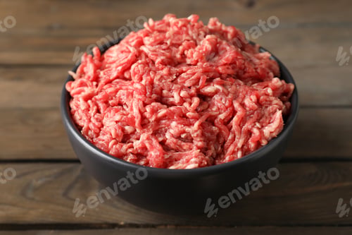 Preview: Raw ground meat in bowl on wooden table, closeup