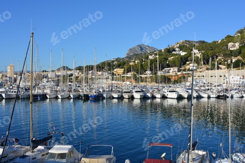 Preview: Picturesque Mediterranean port with boats and reflections in calm sea, early morning