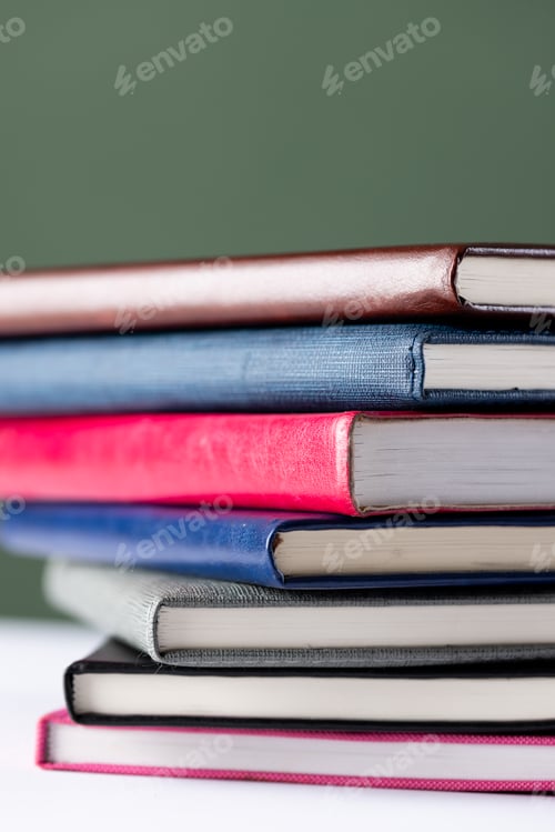 Preview: Close up of stack of books with copy space on green background