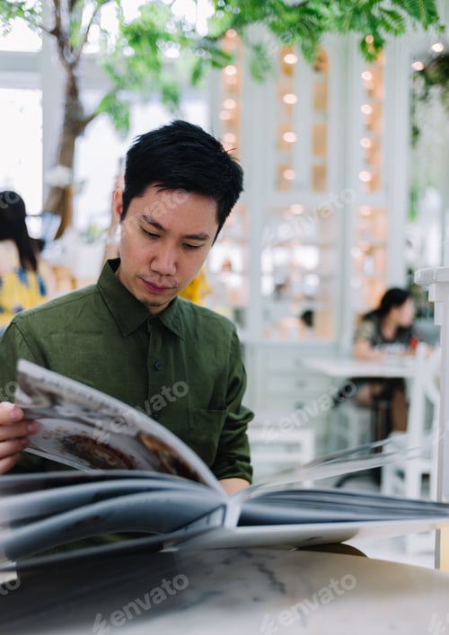 Preview: Man in the cafe looking at the menu
