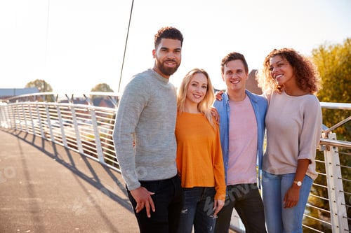 Preview: Portrait Of Young Friends Walking Across City Bridge Together