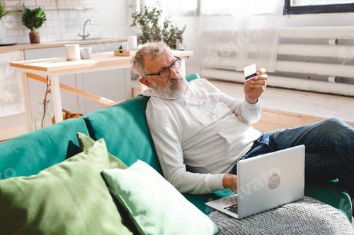 Preview: Senior elderly man making online payments using laptop. Old grandfather doing shopping ecommerce