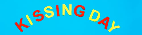 Preview: World Kiss Day. Lettering Kissing day made of colored cardboard on a blue background. Web banner