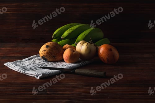 Preview: Closeup shot of tropical fruit on a wooden table with a tablecloth and a knife