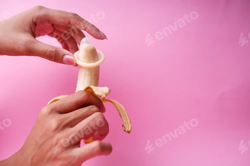 Preview: Man's Hands Holding Peeled Banana With Elastic Condom