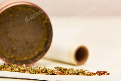 Preview: Marijuana joint with a grinder in the background