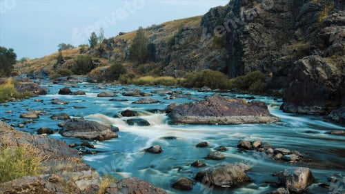 Preview: Beautiful River water flowing through stones and rocks at dawn. Video. Flow of the river through the