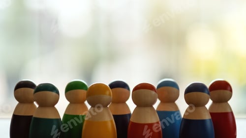Preview: Group of wooden figurines in different colors standing in a row for the concepts of diversity
