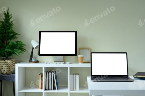 Preview: Modern digital workspace with empty computer monitor, laptop, potted plant, and coffee cup