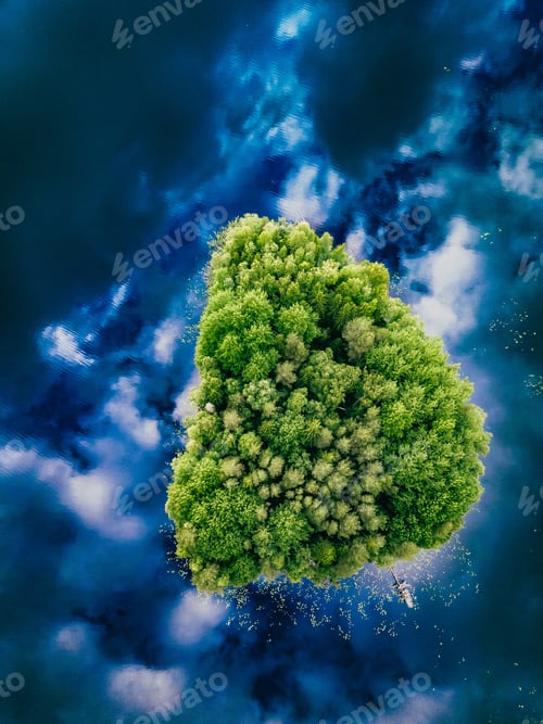 Preview: Aerial view over the small green forest island in blue lake in Finland