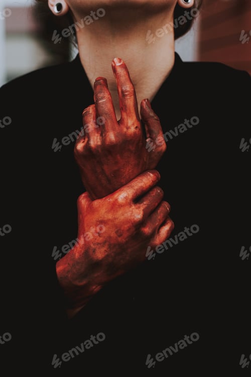 Preview: Vertical closeup shot of a female with red painted hands in pain