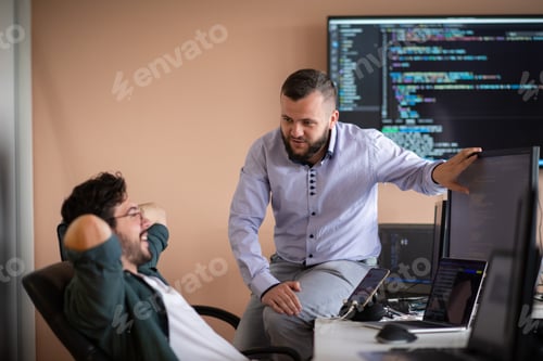 Preview: Programmers engrossed in deep collaboration, diligently working together to solve complex problems