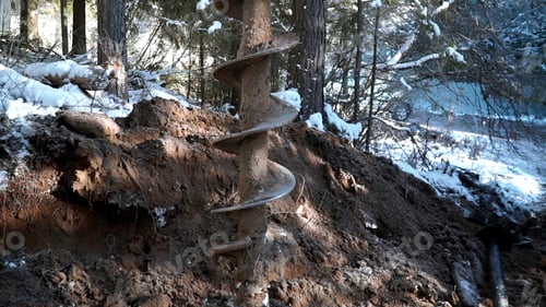 Preview: Drilling cold winter ground in a forest. Clip. Industrial background, construction site in the
