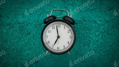 Preview: Retro black alarm clock on green background with copy space.
