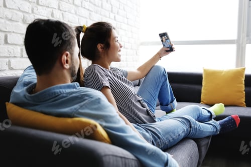 Preview: Young Couple Taking Selfie On Sofa At Home