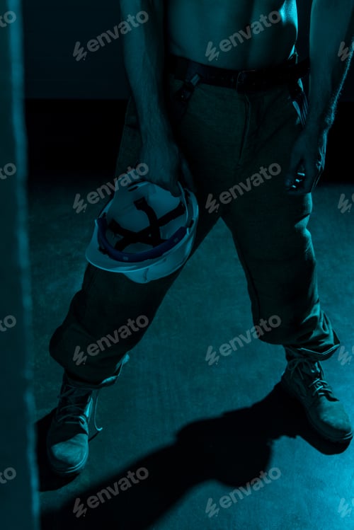 Preview: cropped view of sexy shirtless fireman holding hardhat in darkness