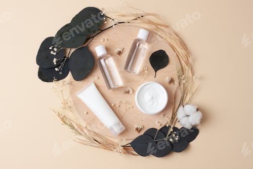 Preview: Cosmetic skin care products with flowers and wood on pastel beige background. Flat lay.