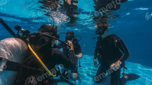 Preview: diving instructor teaches students to scuba dive in swimming pool. couple getting first experience