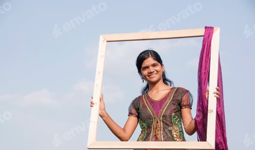 Preview: Young beautiful Indian girl with frame on nature background.