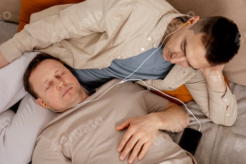 Preview: Happy gay couple with casual clothes spending time together at home and listening music