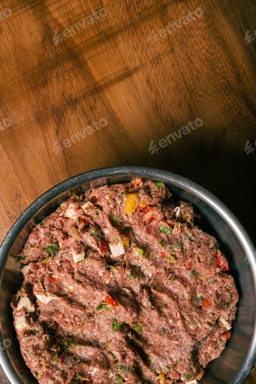 Preview: Ground meat dough prepared for homemade hamburger. Ground meat in metal bowl on wooden table.