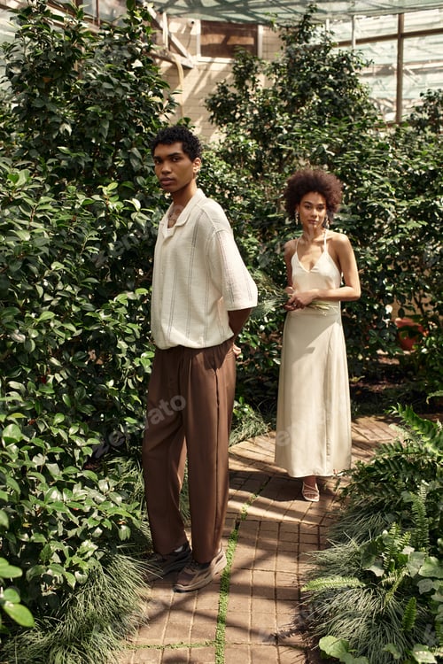 Preview: Young couple shares a tender moment in a lush greenhouse filled with vibrant greenery