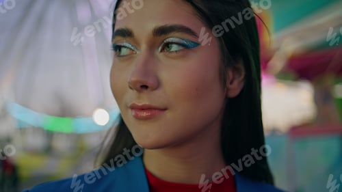 Preview: Closeup fashion beautiful girl resting illuminated amusement park at party night