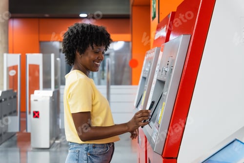 Preview: Positive ethnic lady getting ticket from automatic box in underground station